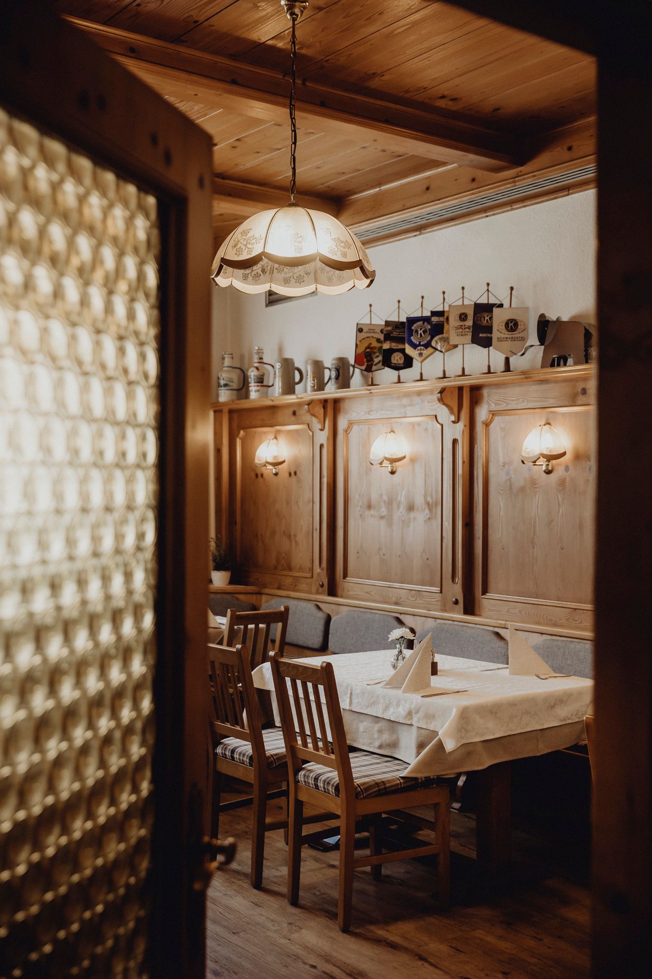Rustikales Interieur mit Holzmöbeln und dekorativen Krügen auf einem Regal.