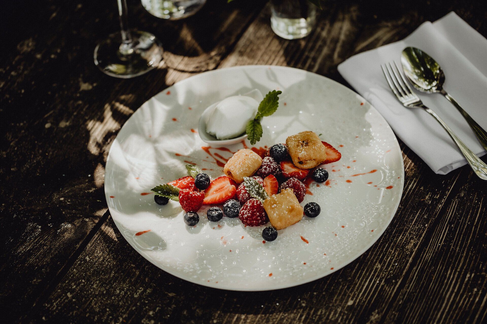 Ein verführerisches Dessert aus gebackenem Topfen, umgeben von frischen Beeren und einem Hauch von Joghurteis, lädt dazu ein, die süßen Momente des Lebens zu genießen. Die harmonische Kombination aus fruchtiger Frische und cremiger Textur verspricht ein unvergessliches Geschmackserlebnis inmitten der idyllischen Weinviertel-Landschaft.