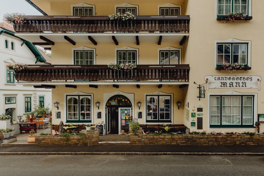 Fassade eines traditionellen Gasthauses mit Balkonen und Blumenkästen.