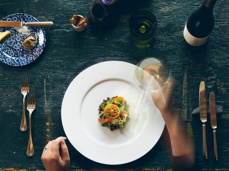 Elegantes Tischgedeck mit Gourmetgericht und Weinglas.