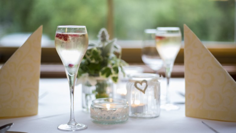 Elegante Tischdekoration mit Sektgl&auml;sern, Kerzen und Servietten.