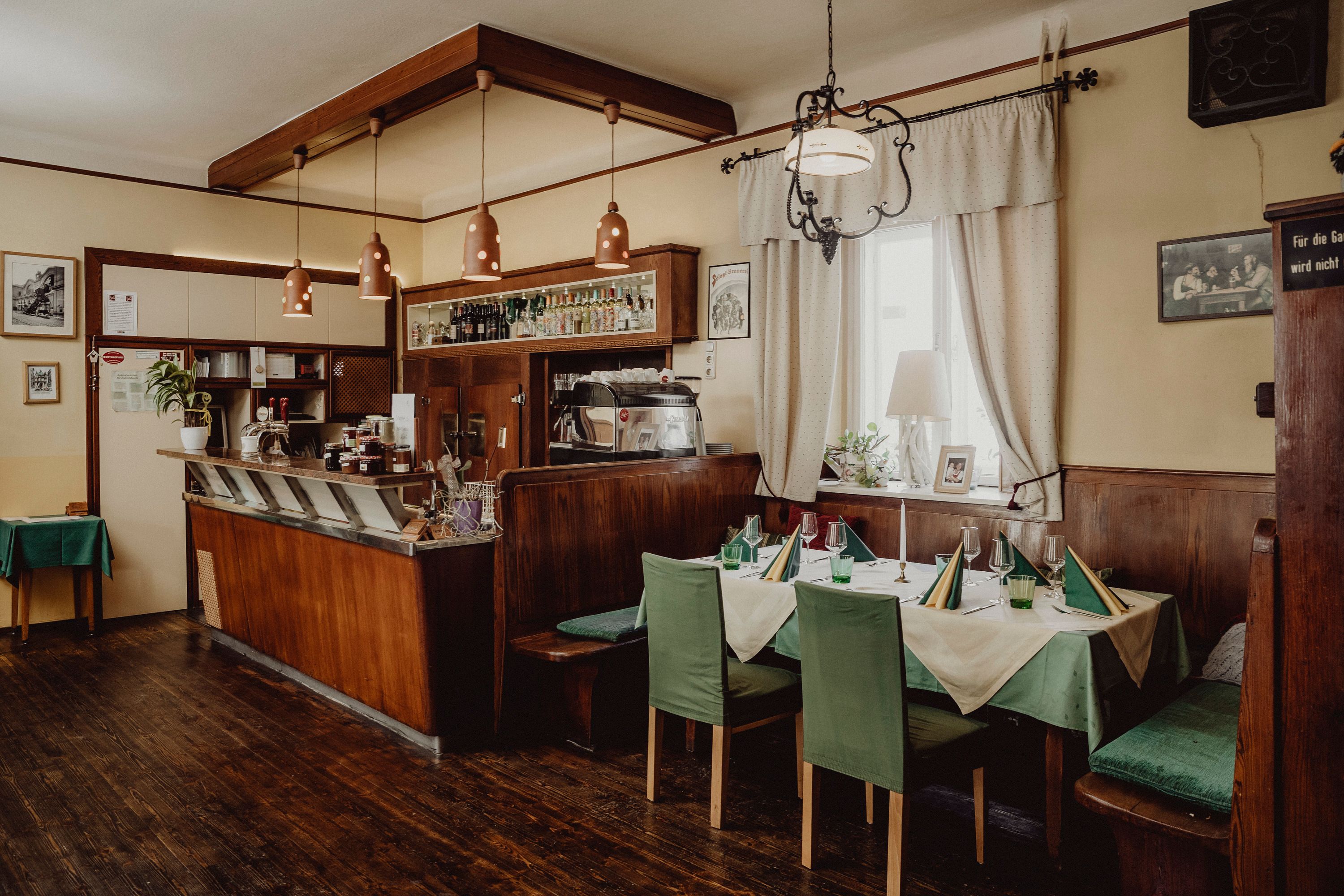 Cozy café with wooden furniture, set table and bar area.