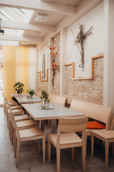 Innenansicht eines modernen Wirtshauses mit Holzm&ouml;beln und Dekoration an den W&auml;nden.