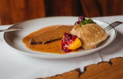 Genießen Sie die herzliche Atmosphäre in einem traditionellen Wirtshaus, wo der Duft von frisch zubereitetem Hirschbraten mit dickem Wurzelsaft und Knödeln die Sinne verführt. Diese kulinarische Köstlichkeit, umgeben von der malerischen Landschaft des Mostviertels, lädt dazu ein, die Seele baumeln zu lassen und die regionale Küche zu entdecken.