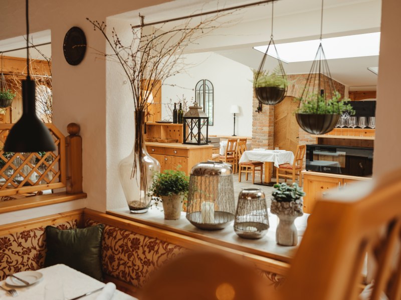 Gem&uuml;tliches Restaurant mit Holzm&ouml;beln und Pflanzen.