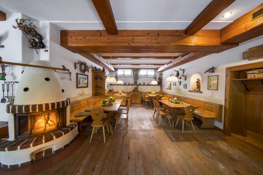 Gem&uuml;tliche Gaststube mit Kamin, Holzm&ouml;beln und rustikaler Dekoration.