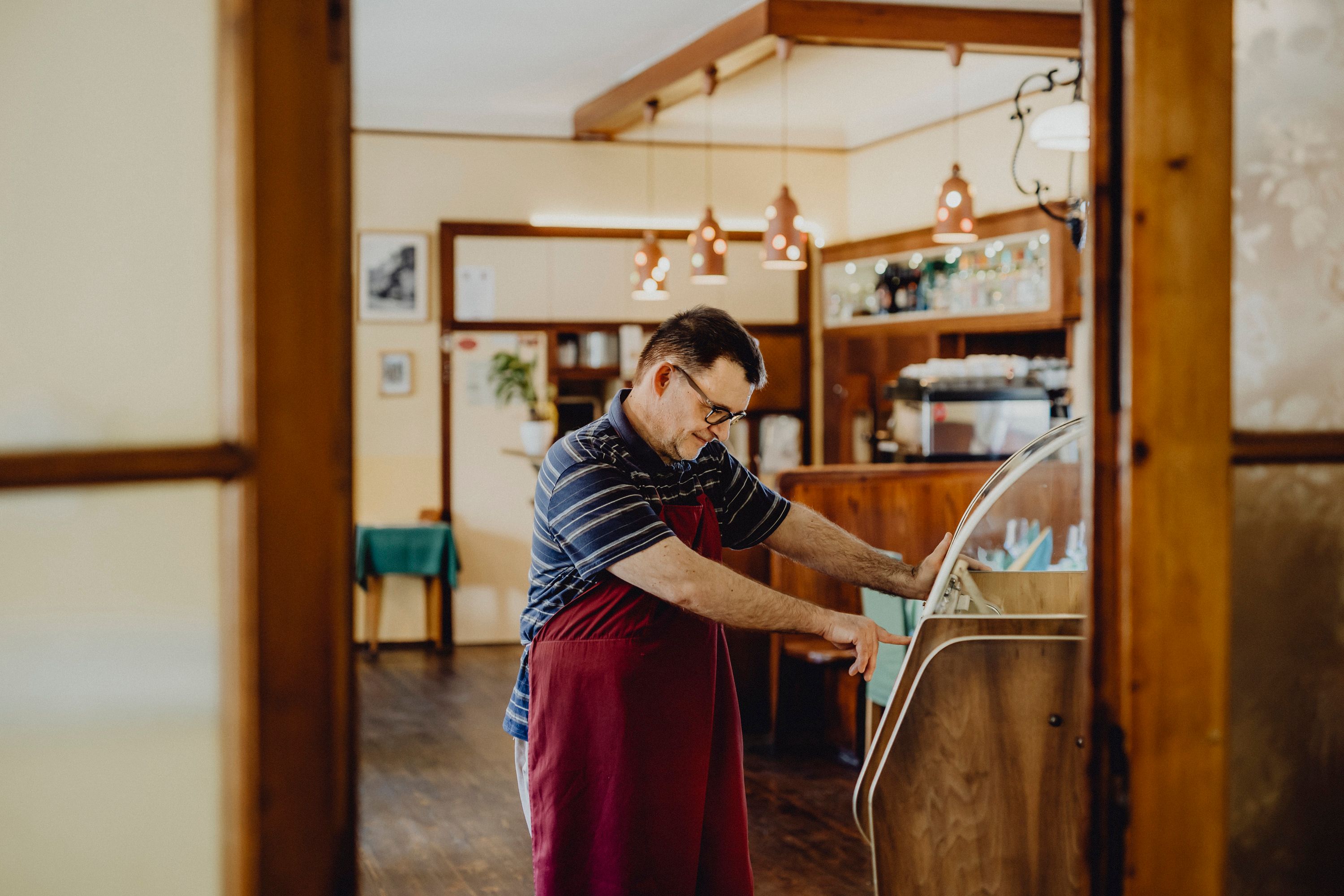 A man in a cozy living room operates a jukebox.