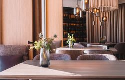 In diesem einladenden Wirtshaus strahlt eine warme Atmosphäre, die zum Verweilen einlädt. Die sanften Lichtakzente und die stilvolle Einrichtung schaffen einen perfekten Ort, um die kulinarischen Köstlichkeiten der Region zu genießen. Frische Blumen auf den Tischen verleihen dem Raum einen Hauch von Natur und Lebensfreude.