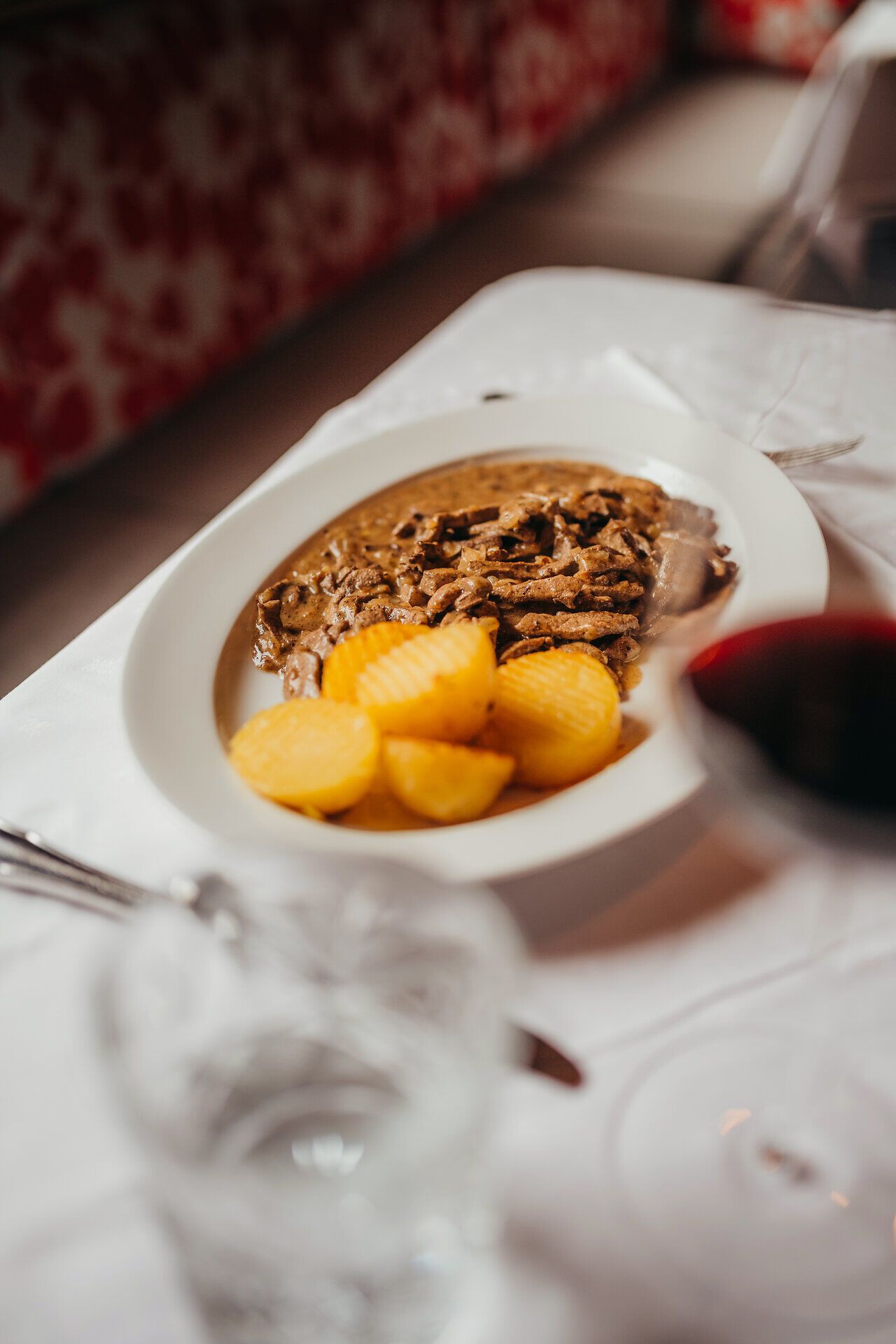 Frau steht vor einer Wand mit Mohnblumenmotiv.