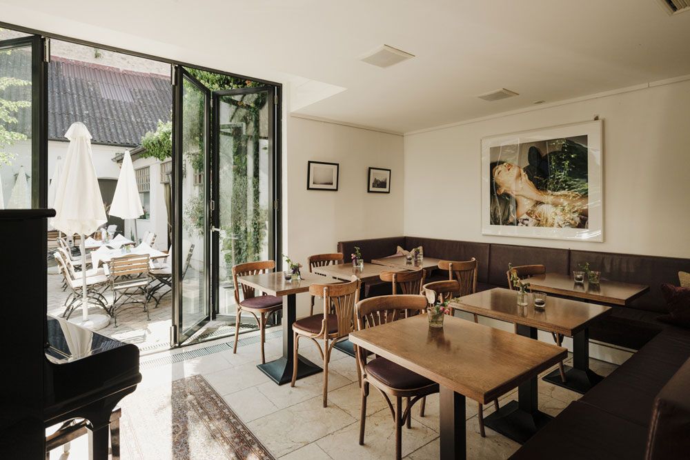Cozy guest room with wooden tables, art on the wall and outdoor terrace.