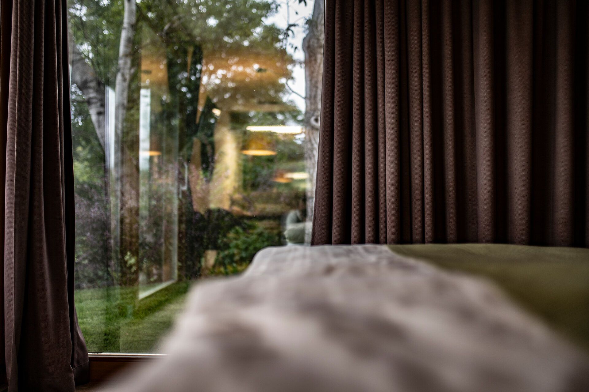 Die sanften Hügel und das üppige Grün der Umgebung laden zu einem entspannten Aufenthalt ein. Durch die großen Fenster strömt das Licht herein und schafft eine harmonische Verbindung zwischen Innen- und Außenbereich. Hier kann man die Ruhe der Natur genießen und den Alltag hinter sich lassen.