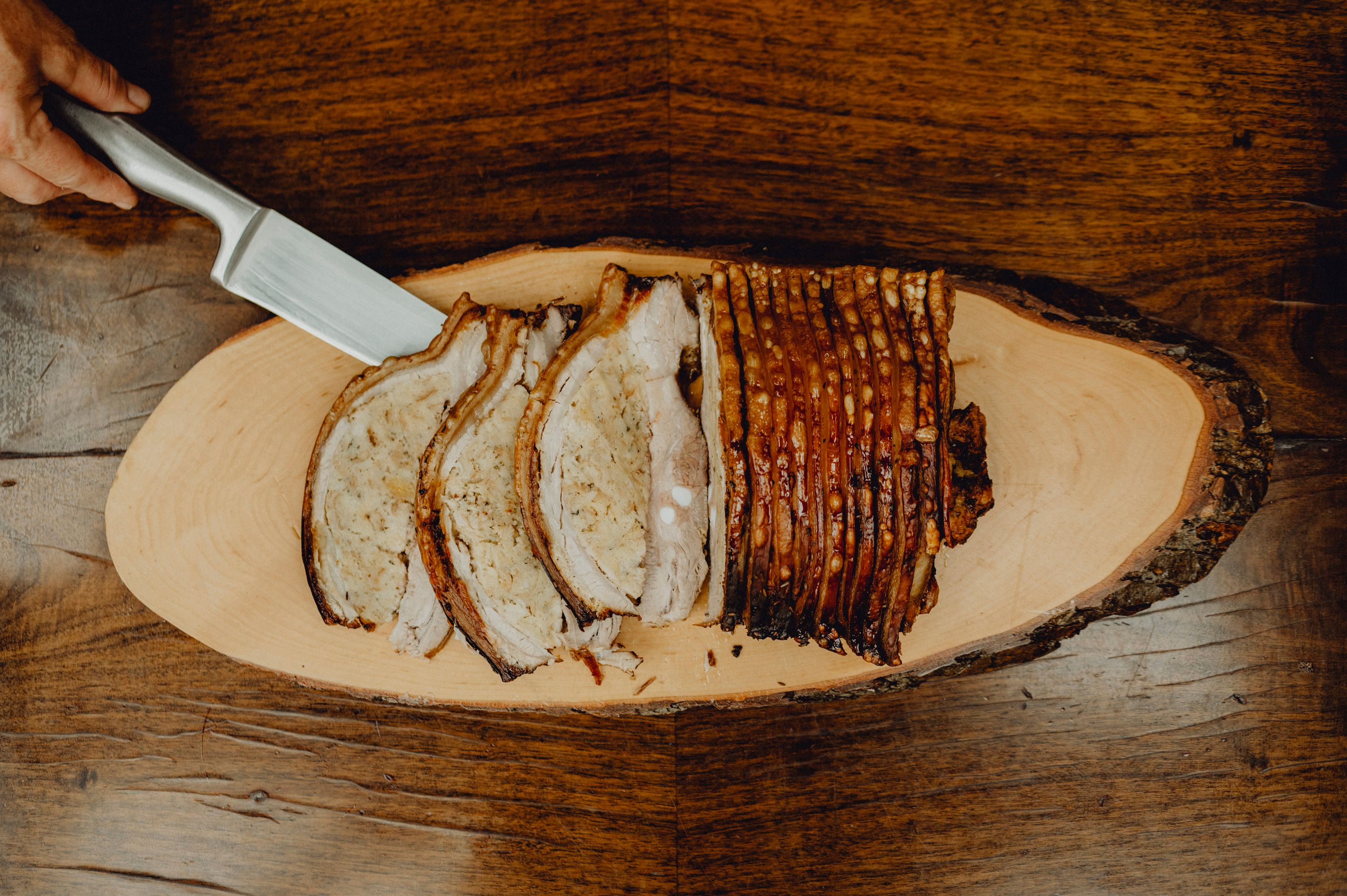 Geschnittener Schweinebraten auf Holzbrett.