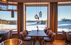 Genießen Sie die atemberaubende Aussicht auf die schneebedeckten Landschaften, während Sie in einem stilvollen Ambiente Platz nehmen. Die großen Fenster lassen das Licht hereinströmen und schaffen eine einladende Atmosphäre, perfekt für eine entspannte Auszeit.