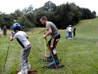 Menschen beim Grasskifahren auf einer Wiese.