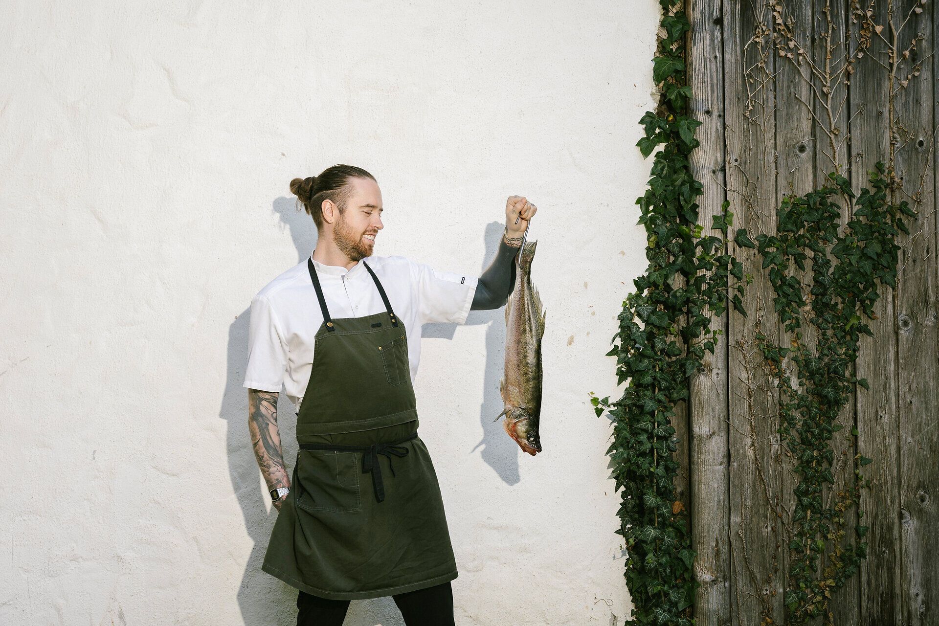 Küchenchef hält einen Fisch in der Hand