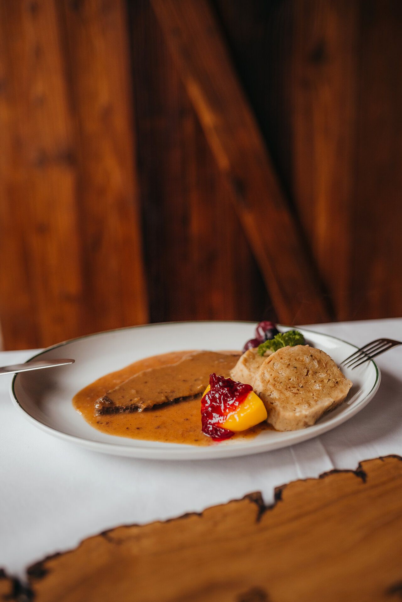 Genießen Sie die herzliche Atmosphäre in einem traditionellen Wirtshaus, wo der Duft von frisch zubereitetem Hirschbraten mit dickem Wurzelsaft und Knödeln die Sinne verführt. Diese kulinarische Köstlichkeit, umgeben von der malerischen Landschaft des Mostviertels, lädt dazu ein, die Seele baumeln zu lassen und die regionale Küche zu entdecken.