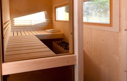 In dieser gemütlichen Sauna aus Holz, umgeben von warmem Licht und der beruhigenden Atmosphäre des Waldes, können Besucher die Seele baumeln lassen. Der Duft von frischem Holz und die sanfte Wärme laden dazu ein, den Alltagsstress hinter sich zu lassen und die Ruhe der Natur zu genießen.