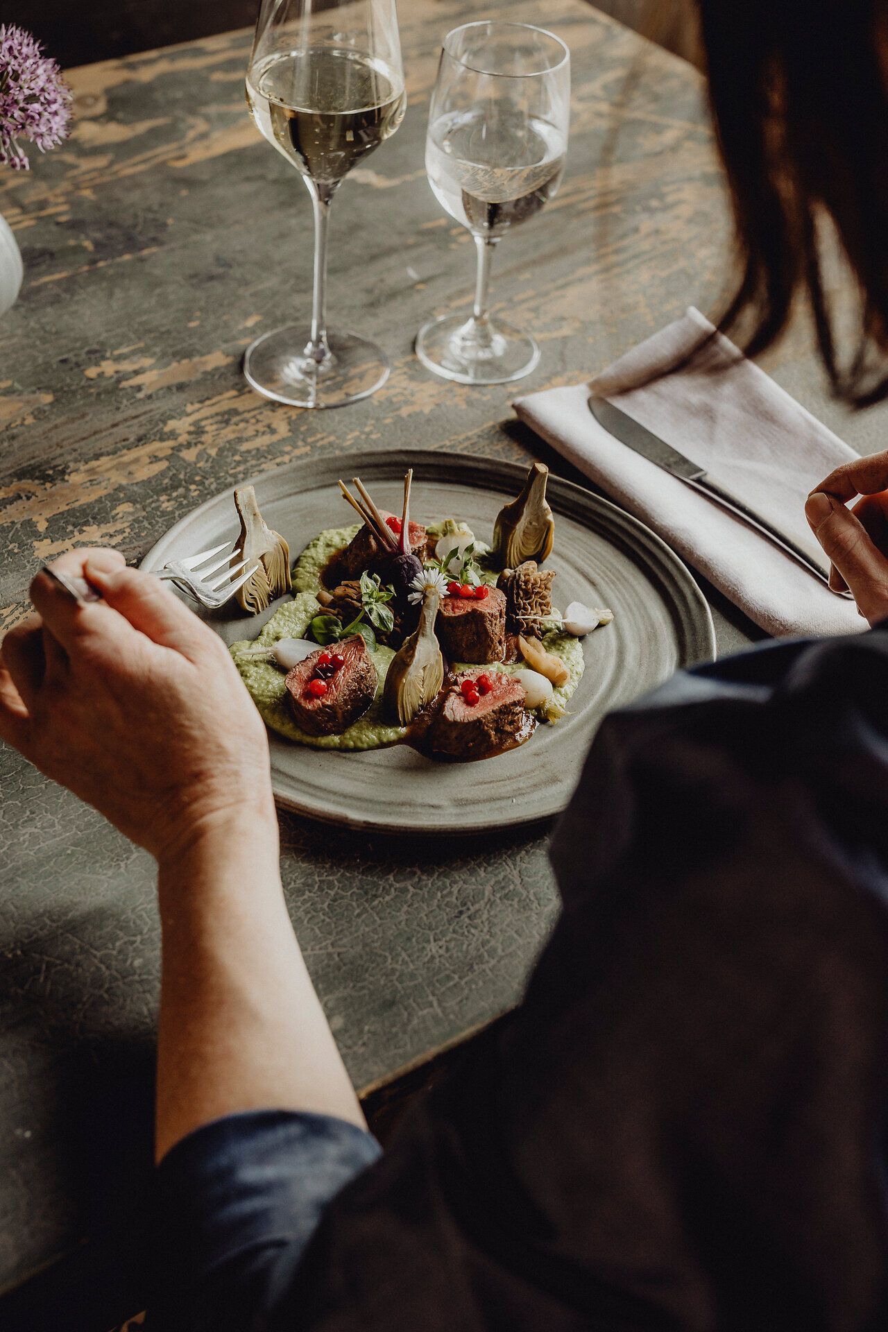 Ein köstliches Gericht aus Rehrücken, kunstvoll angerichtet mit Artischocken, Mandeln und einer feinen Koriandercreme, lädt zu einem genussvollen Erlebnis ein. Die stilvolle Atmosphäre des Wirtshauses verspricht unvergessliche Momente inmitten der kulinarischen Vielfalt Niederösterreichs.