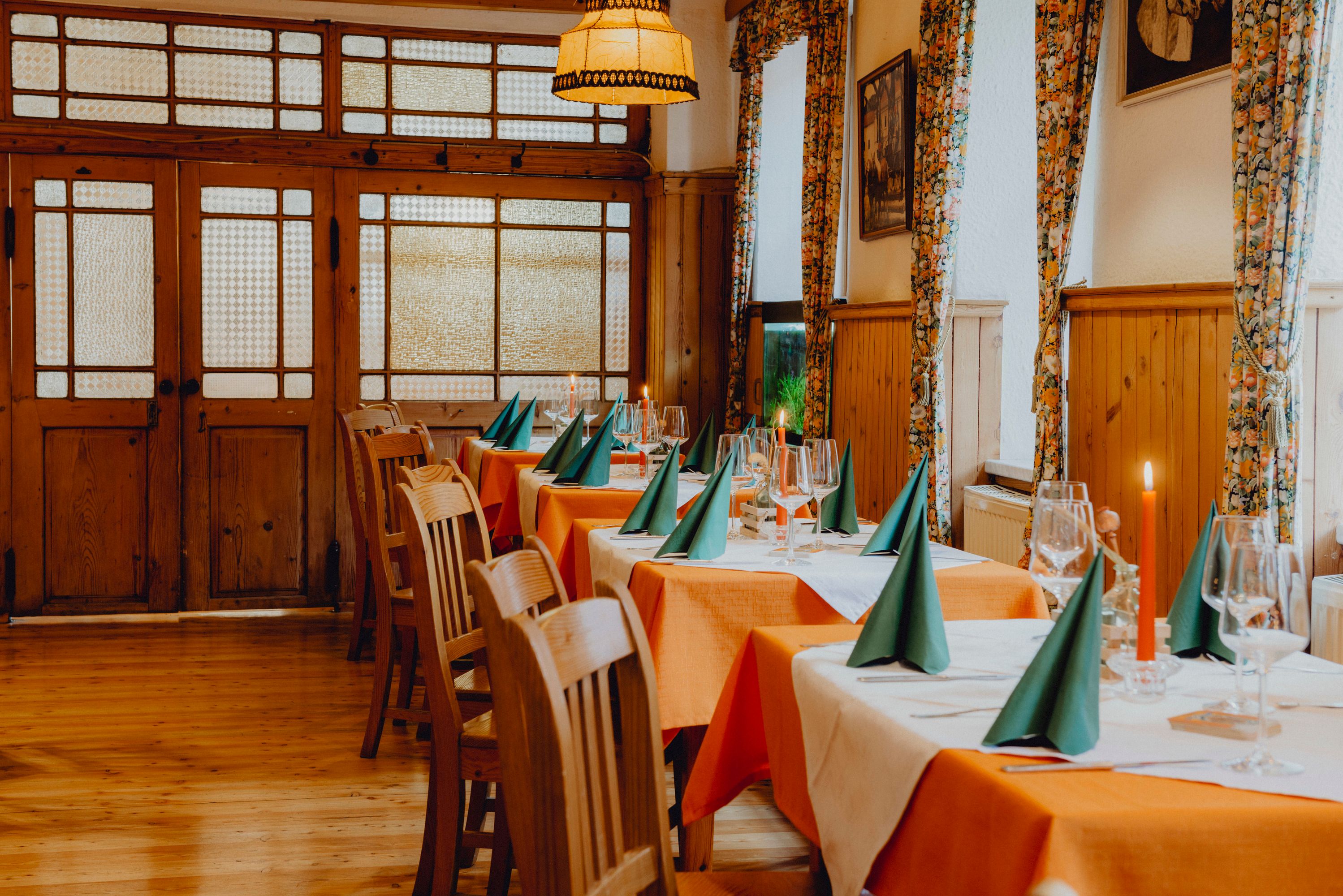 Ein Koch in schwarzer Uniform kocht in einer professionellen Küche mit mehreren Töpfen und Kellen an der Wand.