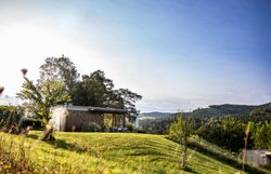 Inmitten sanfter Hügel und üppiger Wiesen strahlt die Ruhe der Natur. Ein modernes Häuschen lädt dazu ein, die atemberaubende Aussicht auf die umliegenden Berge zu genießen. Hier, wo die frische Luft und das sanfte Licht des Morgens harmonisch zusammenkommen, wird jeder Moment zum unvergesslichen Erlebnis.