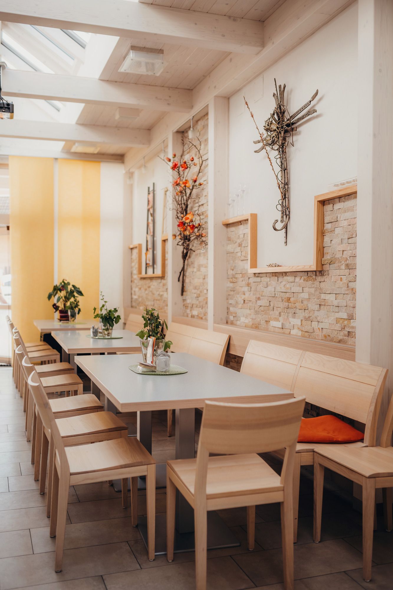 Innenansicht eines modernen Wirtshauses mit Holzmöbeln und Dekoration an den Wänden.