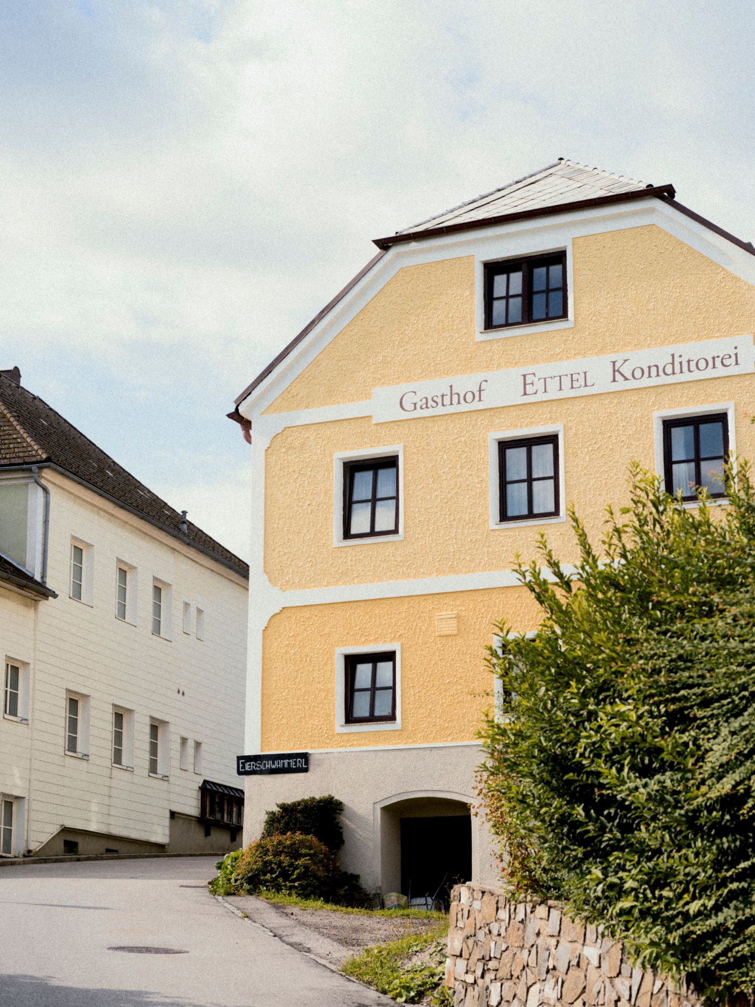 Gelbes Gebäude mit der Aufschrift 'Gasthof Ettel Konditorei' in St. Leonhard.
