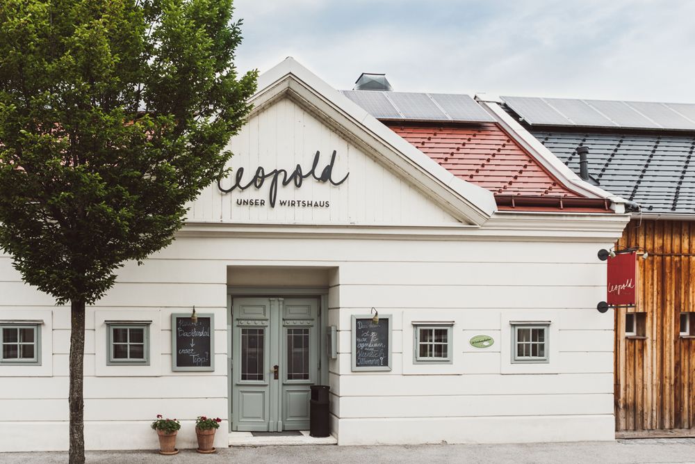 Traditionelles Wirtshaus mit Holzfassade und Solarpanelen auf dem Dach.