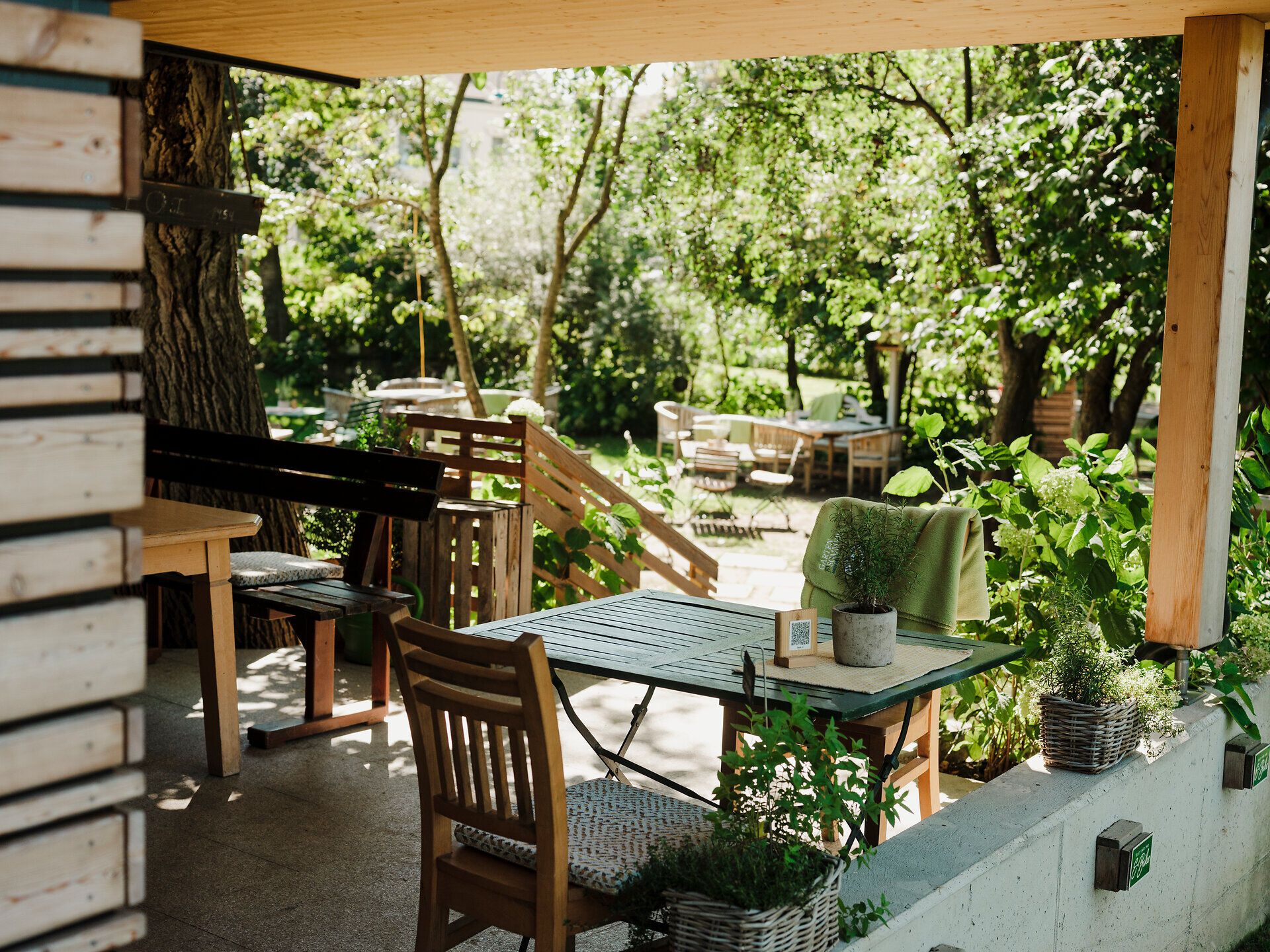 Der einladende Gastgarten ist von üppigem Grün umgeben, wo die sanften Sonnenstrahlen durch die Blätter tanzen. Hier können Besucher die frische Luft und die Ruhe der Natur genießen, während sie sich mit regionalen Köstlichkeiten verwöhnen lassen.