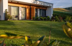 Inmitten einer malerischen Landschaft strahlt das moderne Haus mit seinen klaren Linien und warmen Holzelementen eine einladende Atmosphäre aus. Der gepflegte Garten, umgeben von sanften Hügeln, lädt dazu ein, die frische Bergluft zu genießen und die Ruhe der Natur zu erleben.