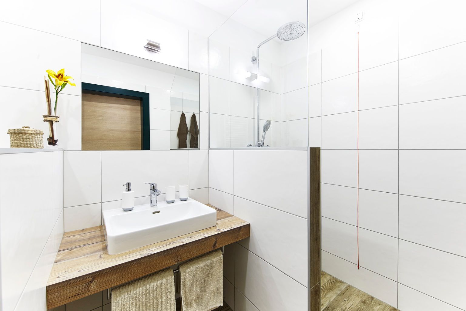 Modernes Badezimmer mit Waschbecken, Spiegel und Dusche.