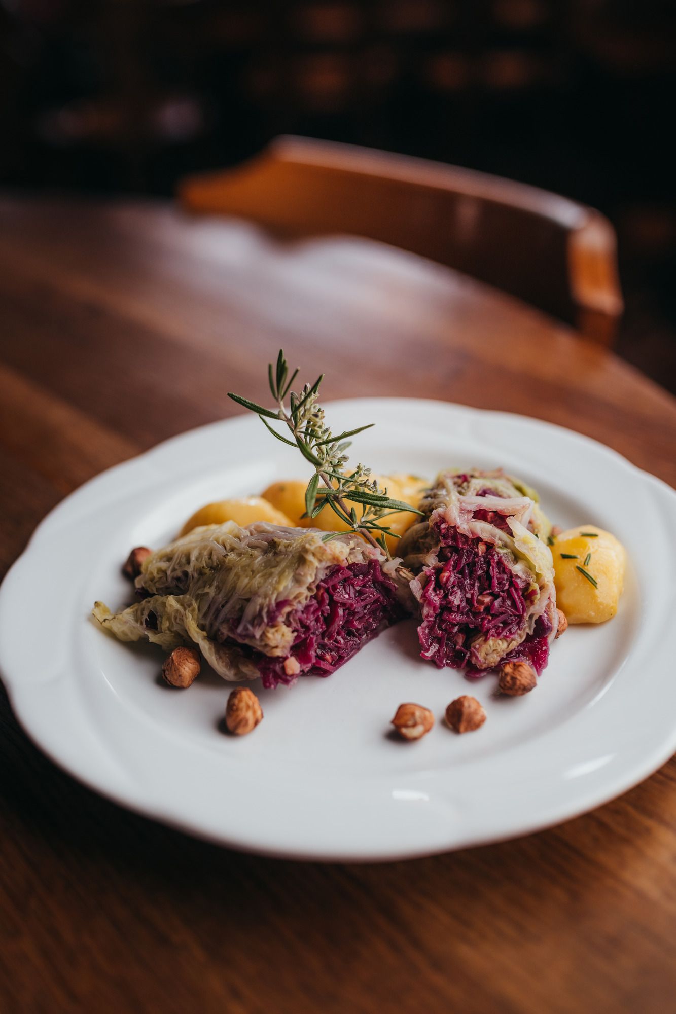Gefüllte Krautblätter mit Nüssen und Kartoffeln auf einem weißen Teller.