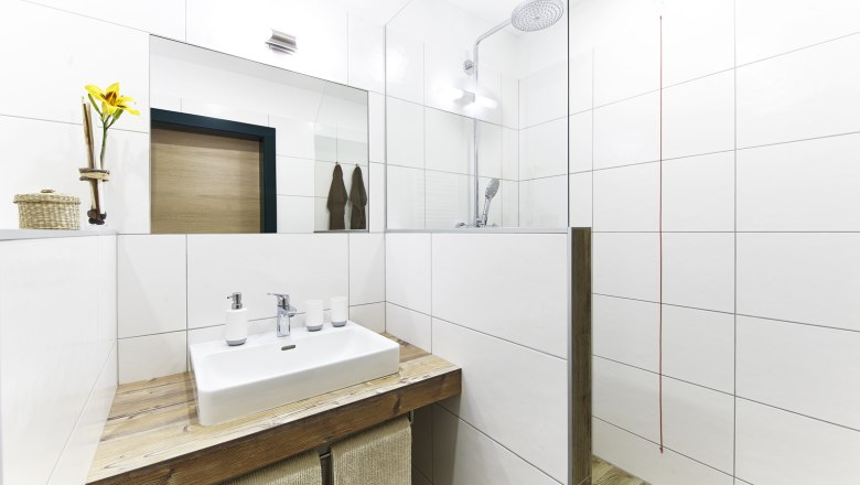 Modernes Badezimmer mit Waschbecken, Spiegel und Dusche.