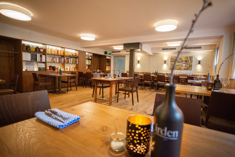 Innenansicht eines gemütlichen Restaurants mit Holzmöbeln und dekorativen Elementen.