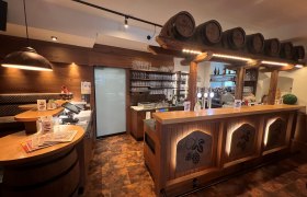 Rustikale Bar mit Holzverkleidung und Bierf&auml;ssern als Dekoration.