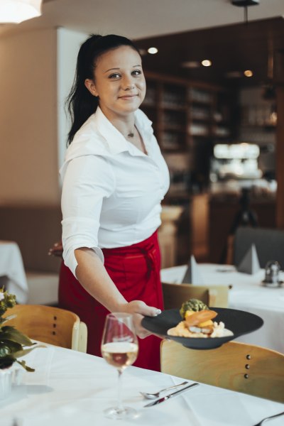 Eine Kellnerin serviert ein Gericht in einem Restaurant.