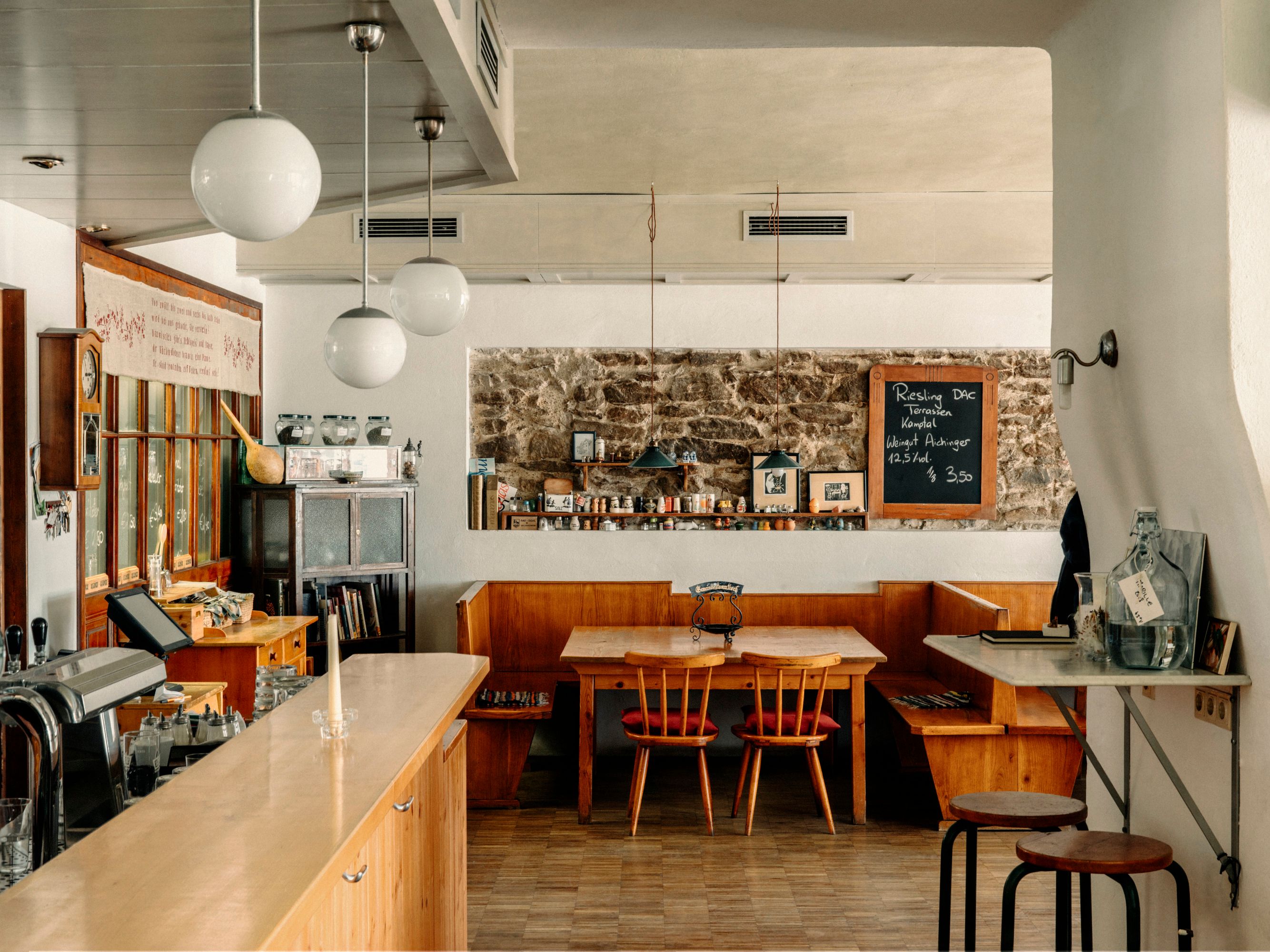 Gemütliches Wirtshaus mit Holzmöbeln und Tafel an der Wand.