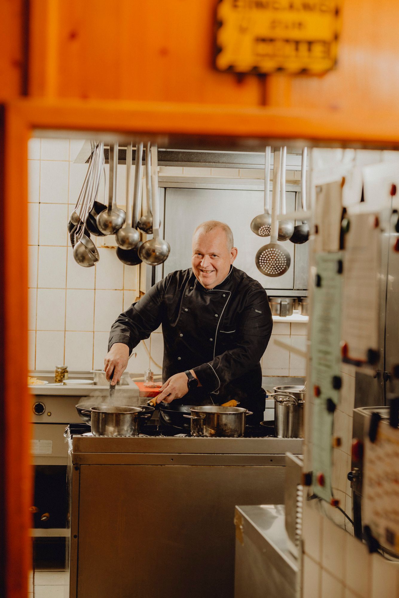 Ein Teller mit Fiakergulasch und ein Glas Bier auf einem Holztisch.