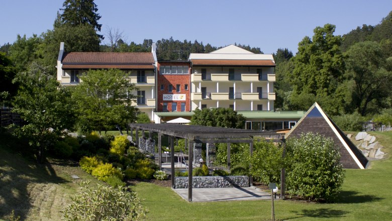Au&szlig;enansicht eines Hotels mit Garten und Pavillon.