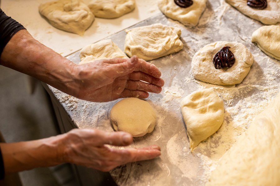 Zubereitung von Germkn&ouml;deln auf bemehlter Arbeitsfl&auml;che.