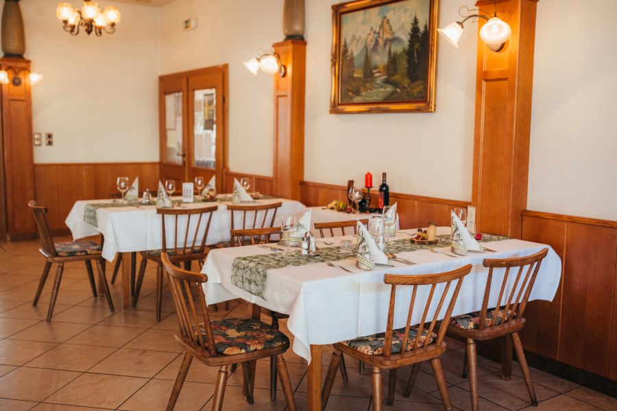Gem&uuml;tliches Restaurant mit gedeckten Tischen und rustikaler Einrichtung.