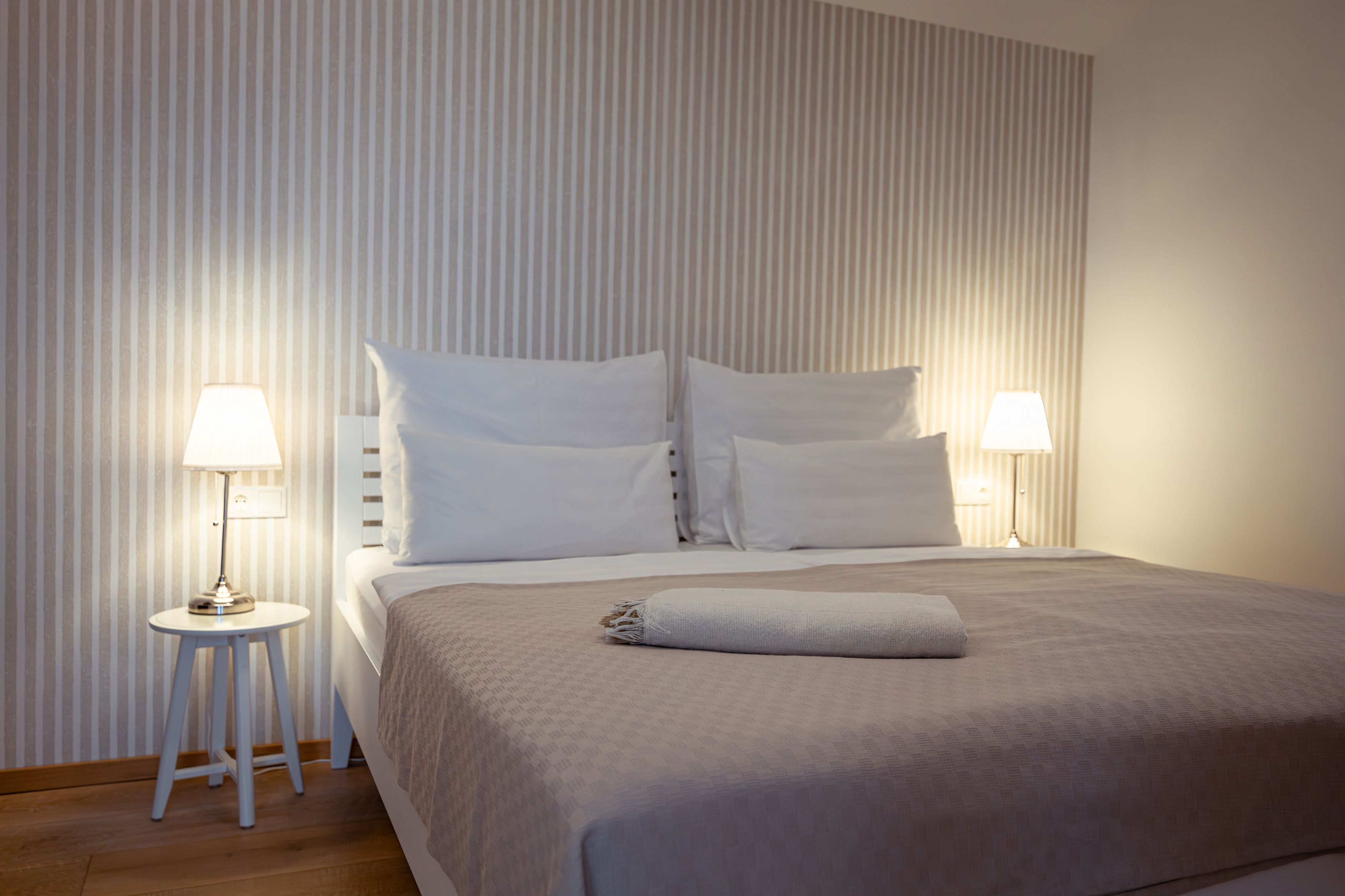 Modern bedroom with double bed, bedside tables and lamps.