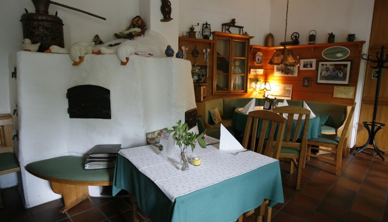 Gem&uuml;tliches Wirtshaus mit rustikaler Einrichtung, Holzm&ouml;beln und Kachelofen.