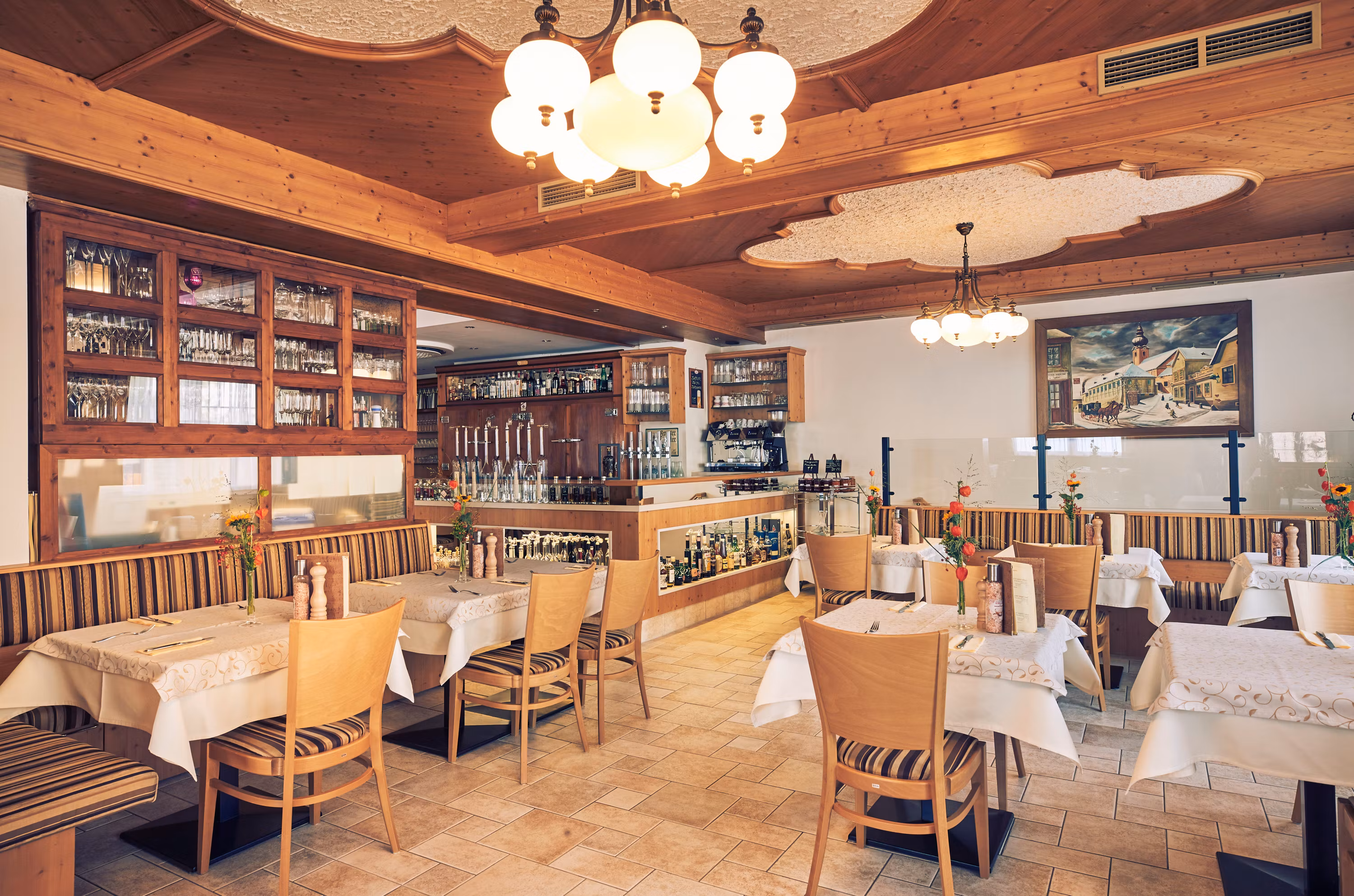Innenansicht eines gemütlichen Restaurants mit Holzmöbeln und dekorativen Leuchten.