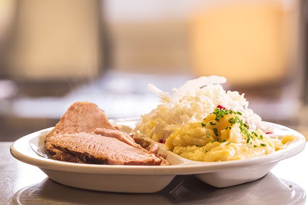 Ein Teller mit Fleisch, Sauerkraut und Kartoffelpüree.