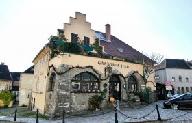 Altes Haus von Au&szlig;en mit Zaun und Parkpl&auml;tzen