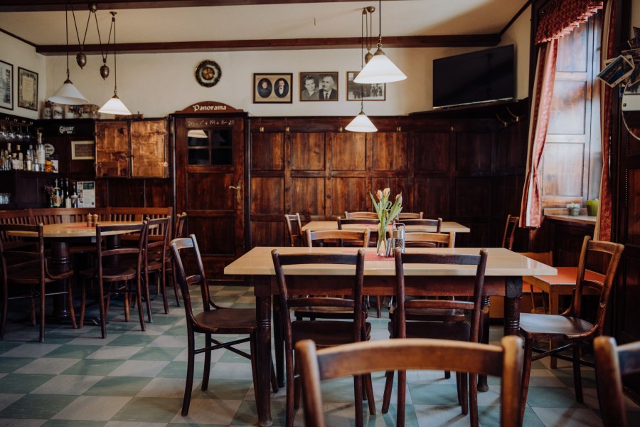 Gemütliches, traditionelles Gasthaus mit Holzmöbeln und dekorativen Bildern.