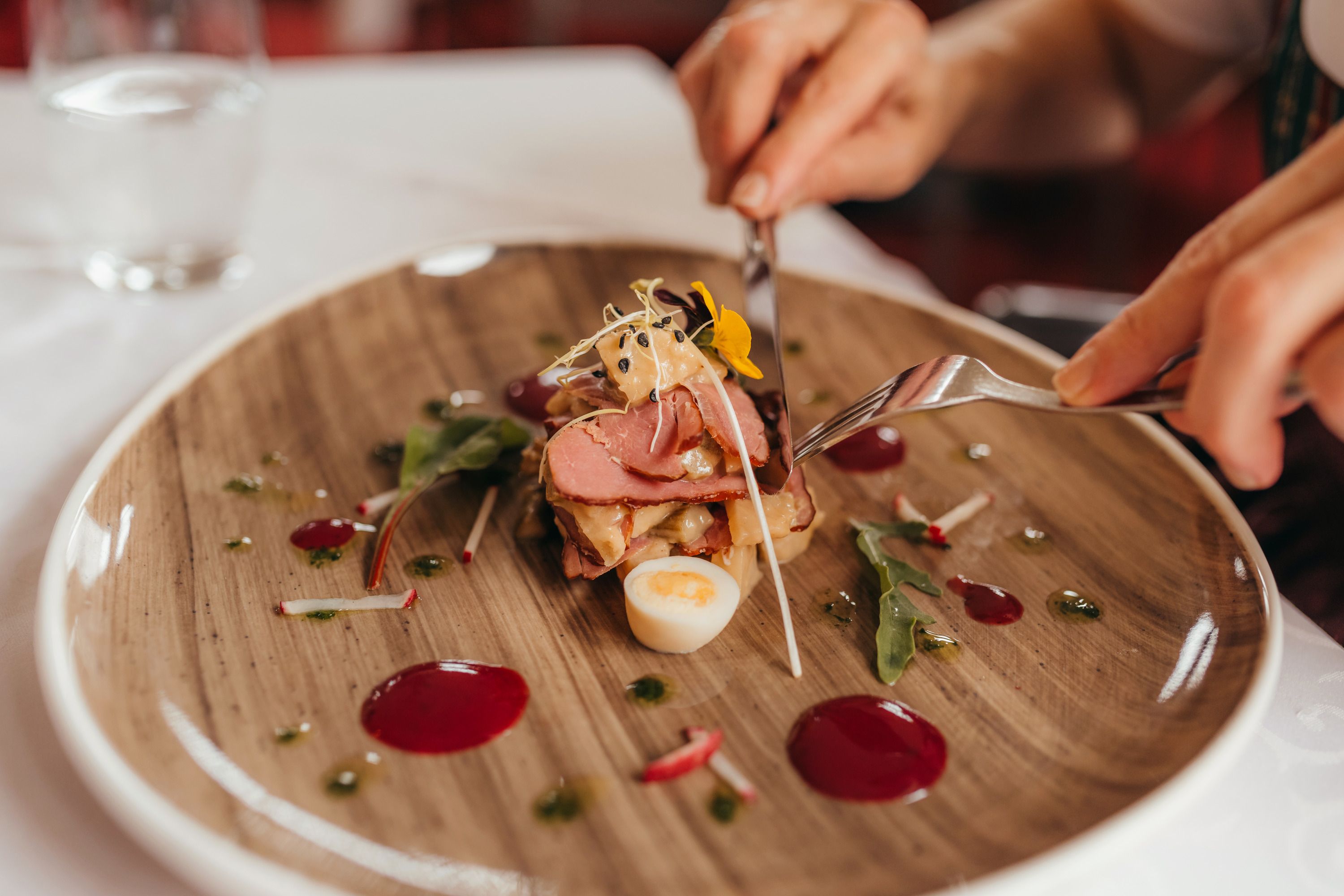 Ein Teller mit geräucherter Entenbrust, Zwetschken-Schalotten-Chutney und Dekorationen.