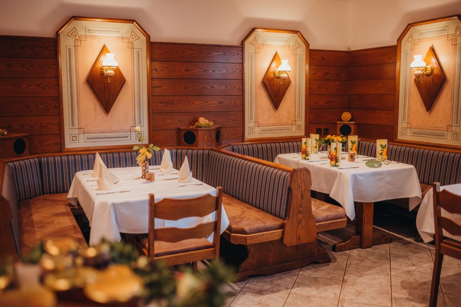 Gem&uuml;tliches Restaurant mit Holzw&auml;nden und dekorierten Tischen.