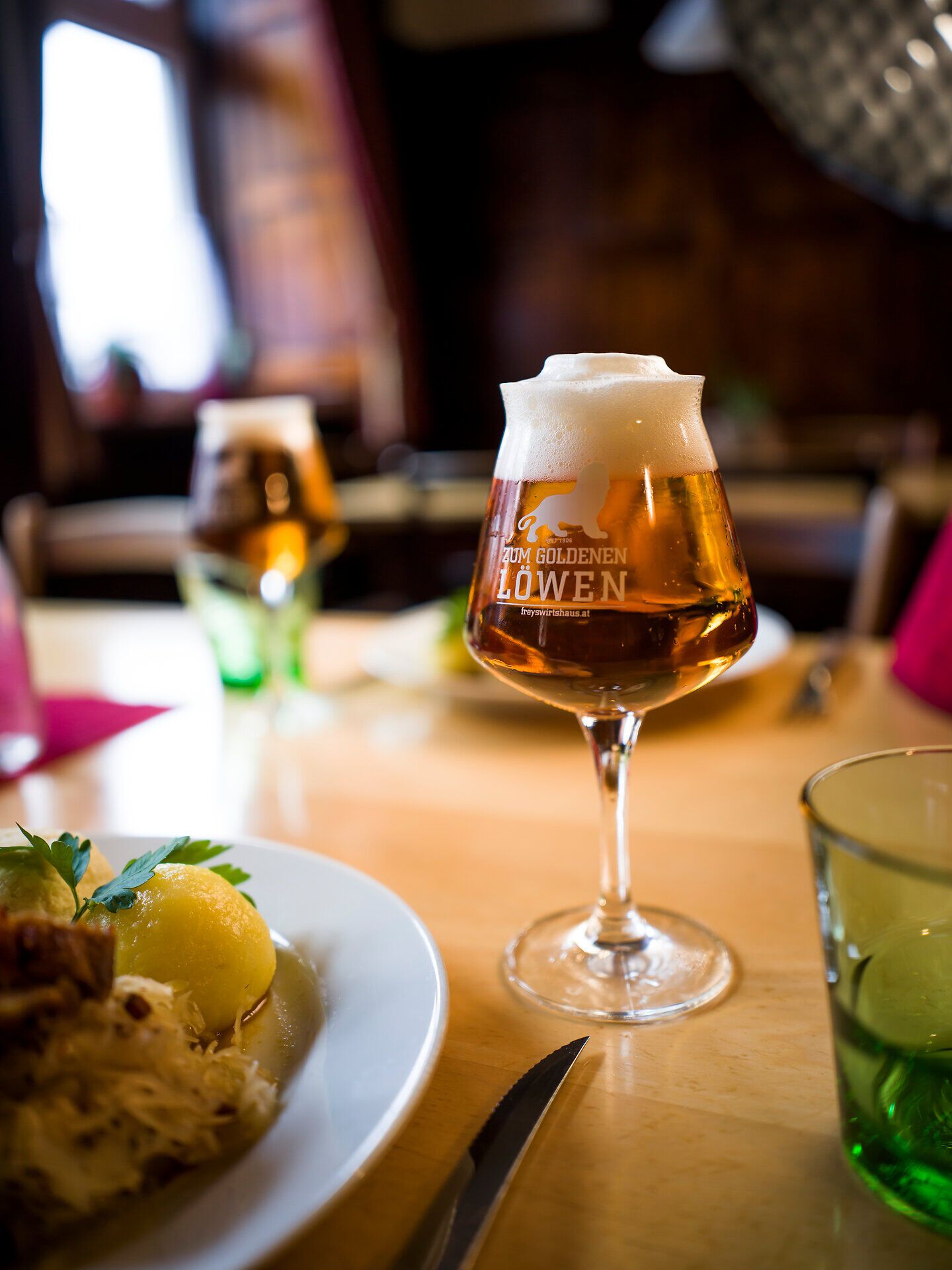 Eingedeckter Tisch mit Bierkrustenbraten und Glas Bier im Wirtshaus Zum Goldenen Löwen in Maria Taferl im Nibelungengau