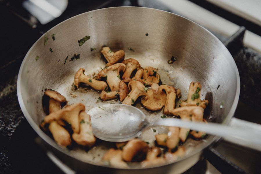 Pfifferlinge in einer Pfanne mit Kr&auml;utern.